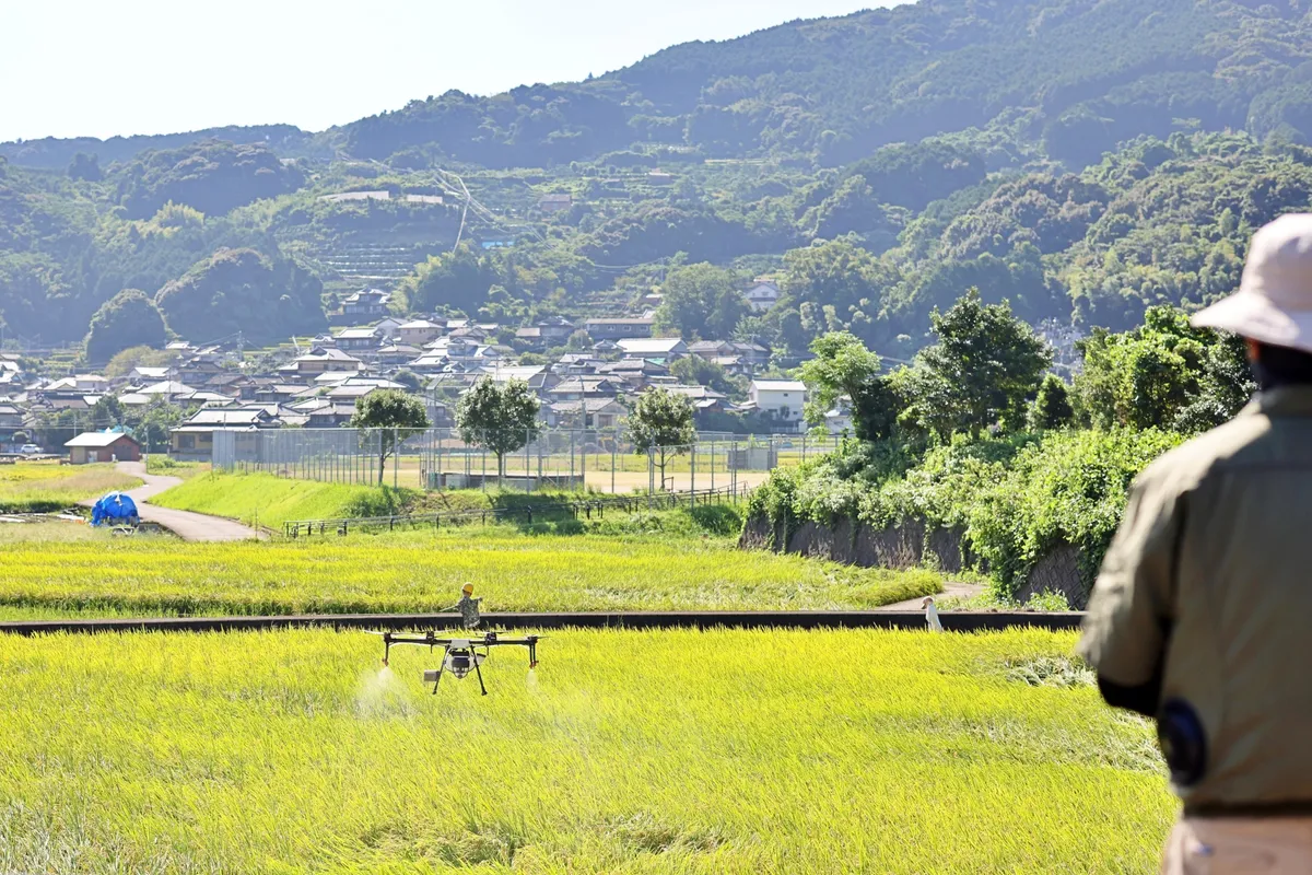 田園地帯の上空を飛ぶ農業用ドローン